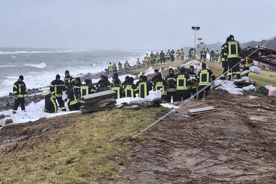 Feuerwehrleute helfen nach der Sturmflut bei der Deichsicherung in Maasholm: Jetzt ist schon wieder ein neues Sturmtief im Anmarsch.