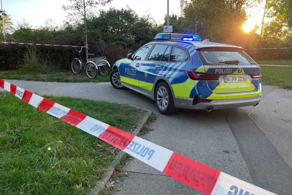 Ein Polizeiauto steht in der Nähe des Tatorts in Ansbach. Der 30-jährige Angreifer wurde von Beamten erschossen.
