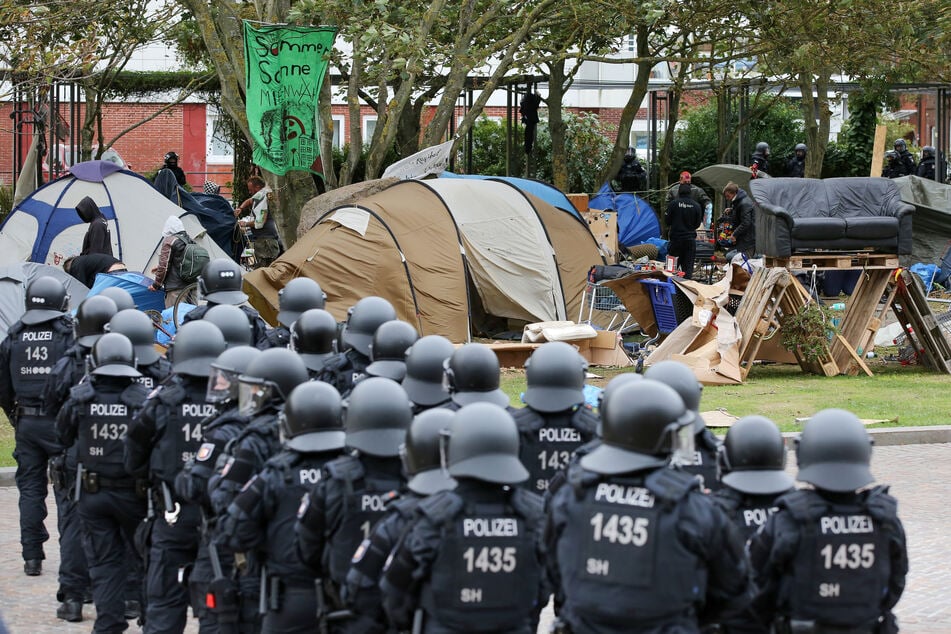 Polizisten verfolgen die Räumung des Punk-Protestcamps.