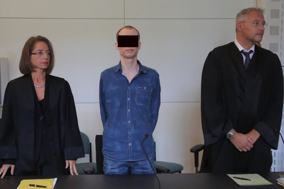 Nino K. hört dem Richter mit eingefrorenem Lächeln bei der Verkündung des Urteils zu.