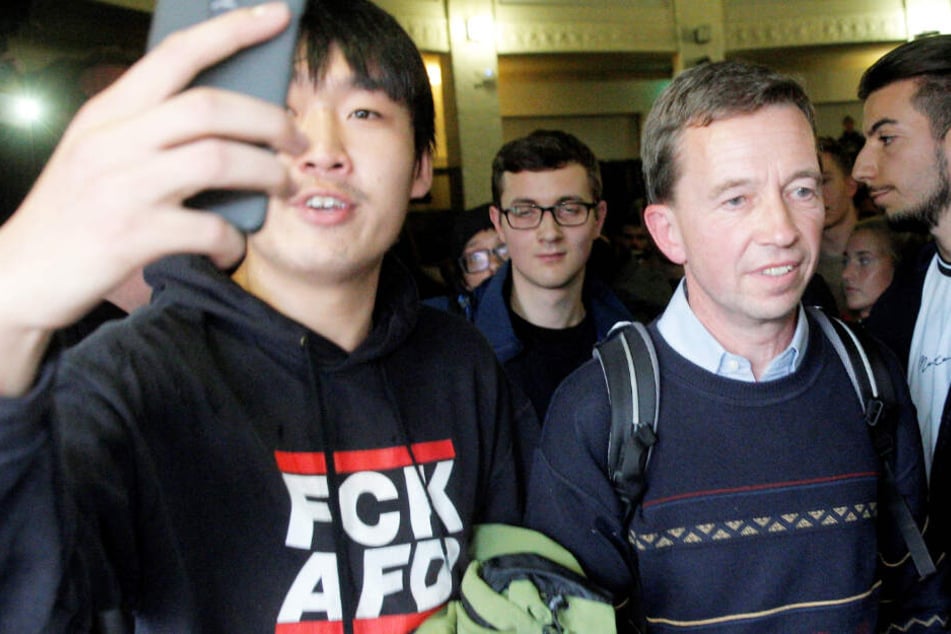 Während Bernd Lucke die Vorlesung abbricht, macht ein junger Mann ein Selfie mit dem AfD-Gründer.