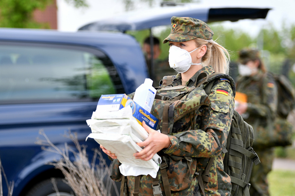 Eine Bundeswehrsoldatin trägt Schutzausrüstung in ein Testzelt für ein Corona-Screening. (Symbolbild)