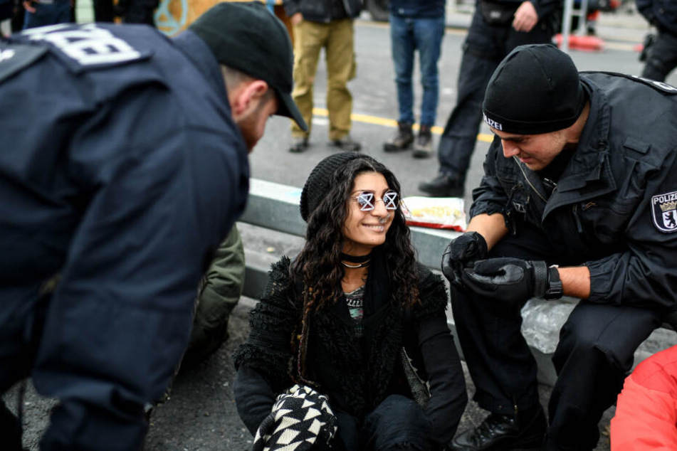 Polizisten versuchen eine Aktivistin auf dem Mühlendamm an der Mühlendammbrücke zum Verlassen der Brücke zu bewegen.