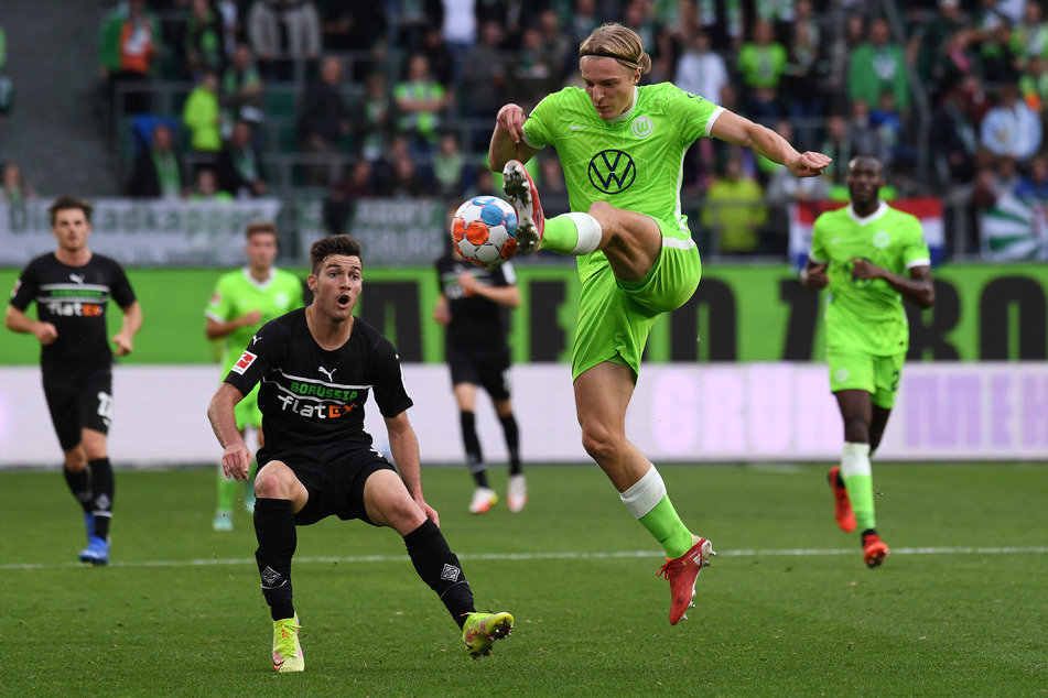 Sowohl defensiv als auch offensiv gefordert: Borussias Joe Scally (18, v.l.) blickt auf die Ballannahme von Wolfsburgs Sebastiaan Bornauw (22, v.r.).