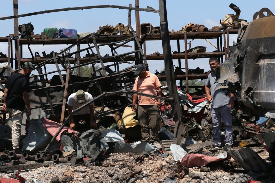 People inspect the damage at the site of an overnight Israeli strike in the southern Lebanese village of Deir Seryan, in the Nabatieh district, on August 7, 2025.