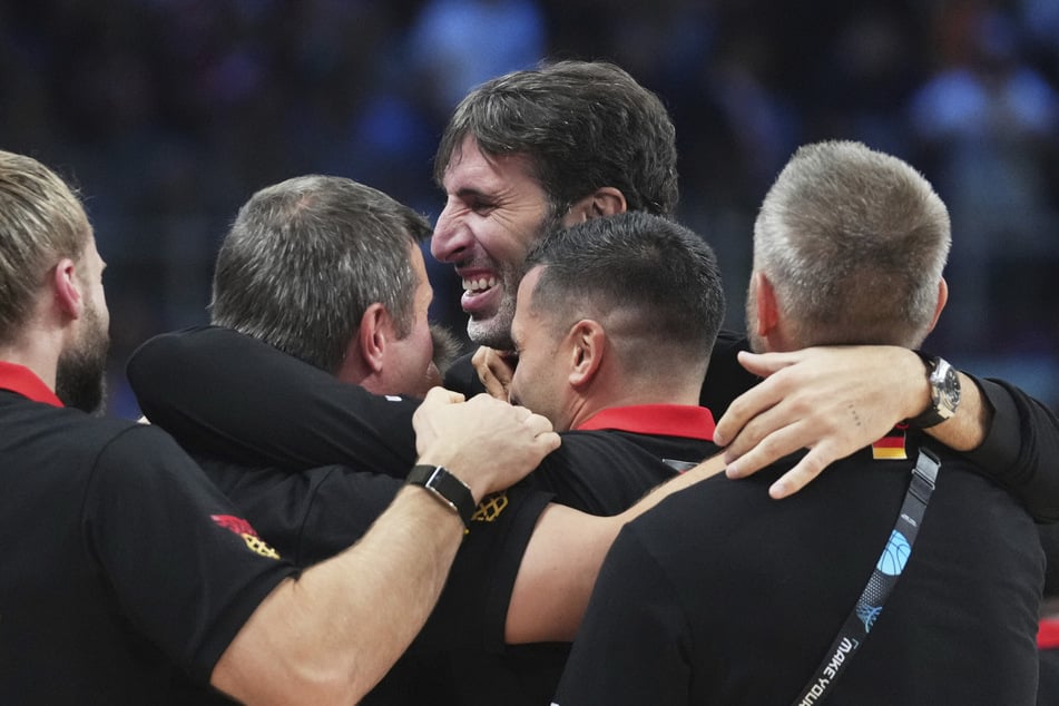 Alex Mumbru (M.) feierte mit Ersatz-Cheftrainer Alan Ibrahimagic und dem Rest des Trainerteams.