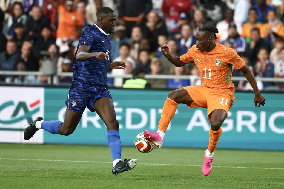 Yan Diomande (19, .) gewann mit der Elfenbeinküste gegen Frankreich um den Ex-Leipziger Ibrahima Konaté (27, l.).