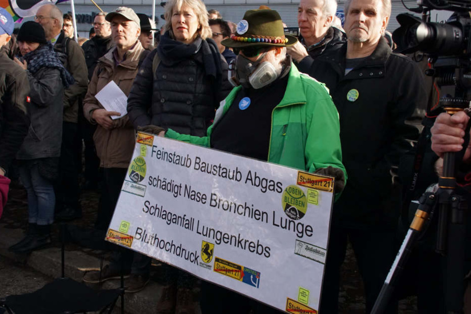 Ein Teilnehmer einer Feinstaub-Demonstration mit einem Plakat deutet auf die Gefahren hin.