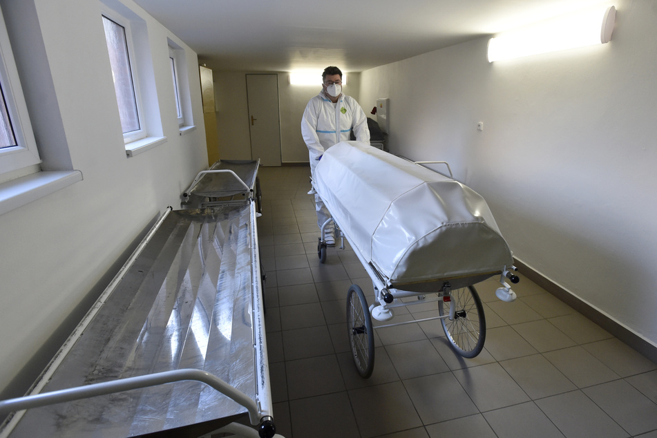 Tschechien, Zlin: Ein medizinischer Mitarbeiter in Schutzkleidung schiebt eine Leiche in die Pathologie des Regionalkrankenhauses.