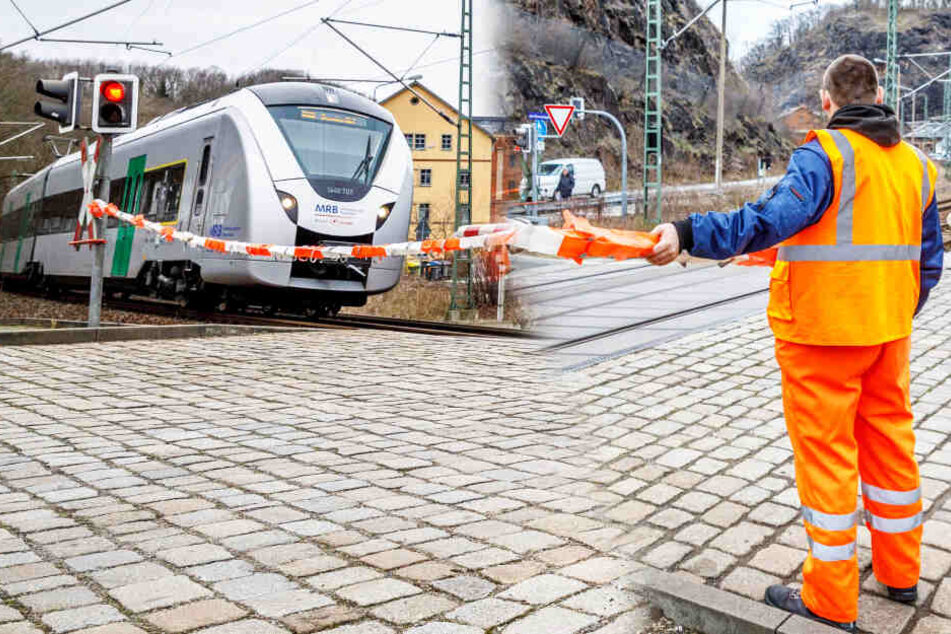 Bahn-Mitarbeiter spielen am Dresdner Eiswurmlager Schranke mit Flatterband