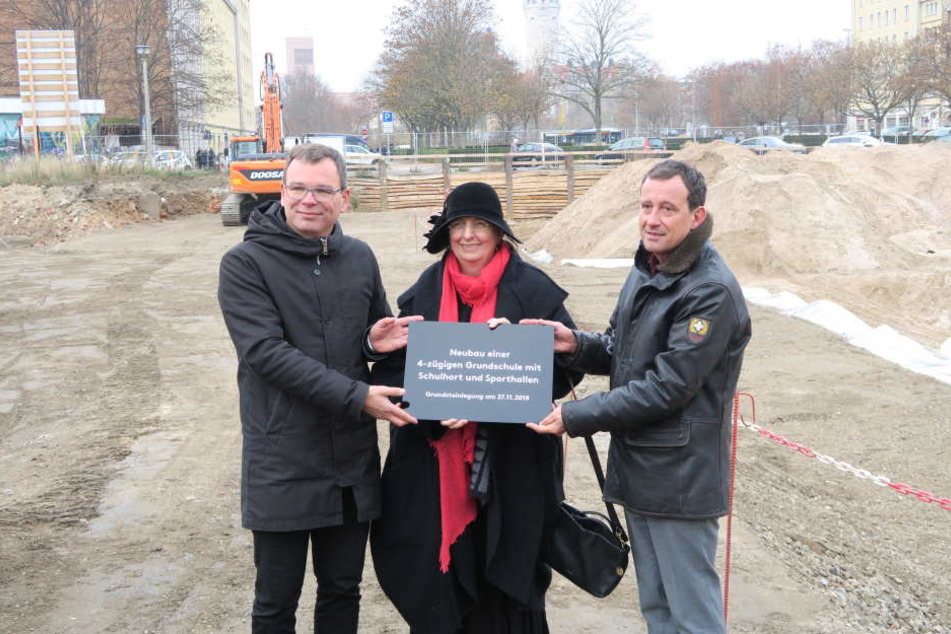 Baubürgermeisterin Dorothee Dubrau (Mitte) zusammen mit Architekt Benedikt Schulz (links) und Nicolas Tsapos, Amtsleiter für Jugend, Familie und Bildung (rechts), bei der Übergabe der Erinnerungstafel.