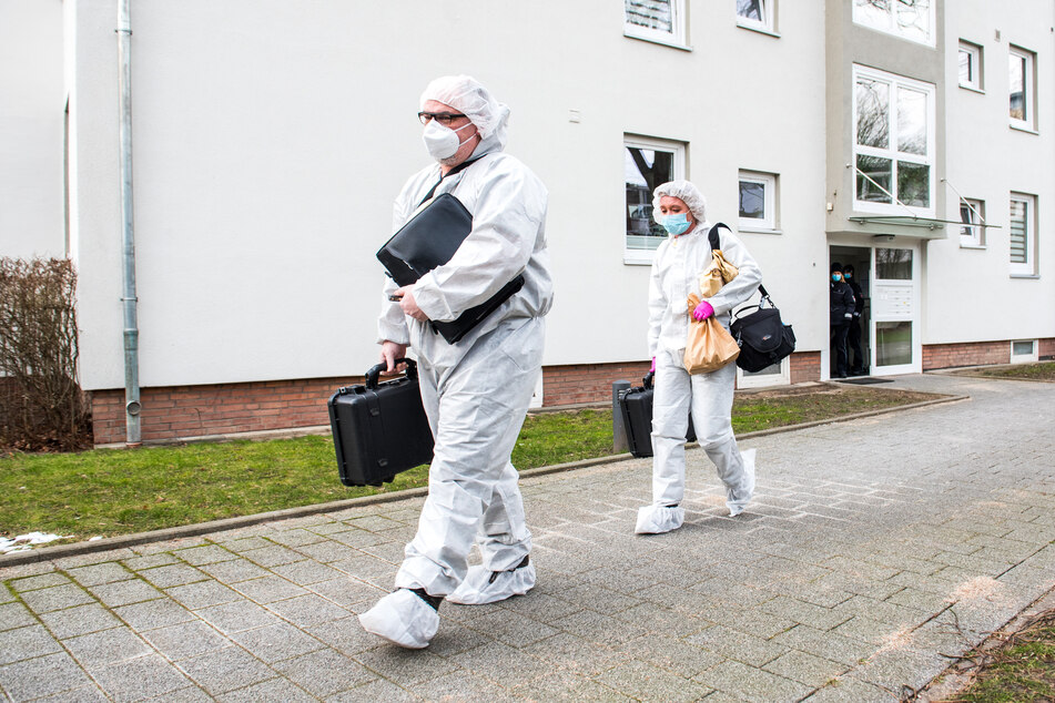 Ermittler der Spurensicherung kommen aus dem Mehrfamilienhaus, in dem der 28-Jährige seine Mutter umgebracht haben soll.