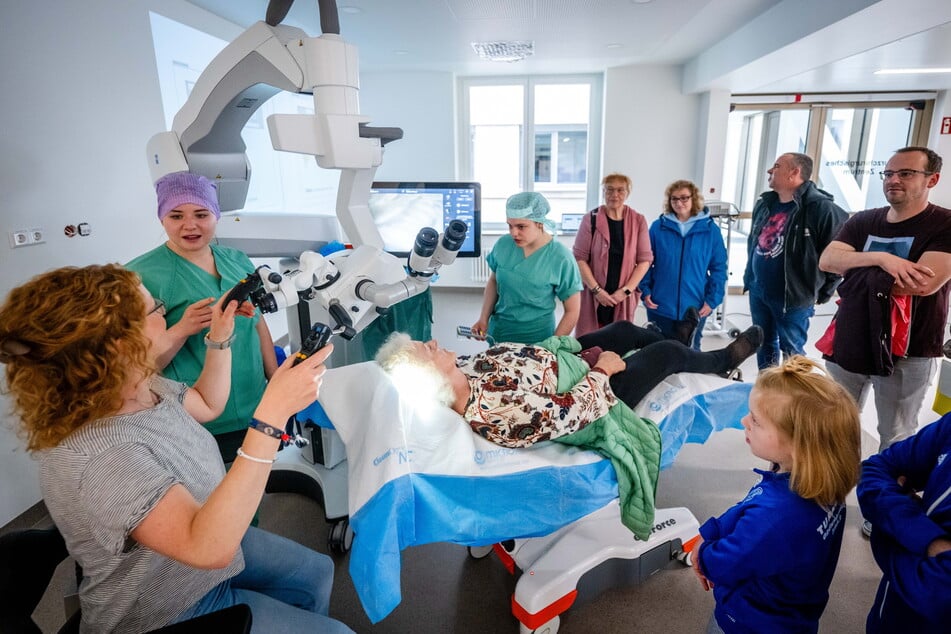 Operationstechnische Assistentin Lena Riedel (2.v.l.) zeigte Besuchern ein modernes Mikroskop für Augenoperationen.