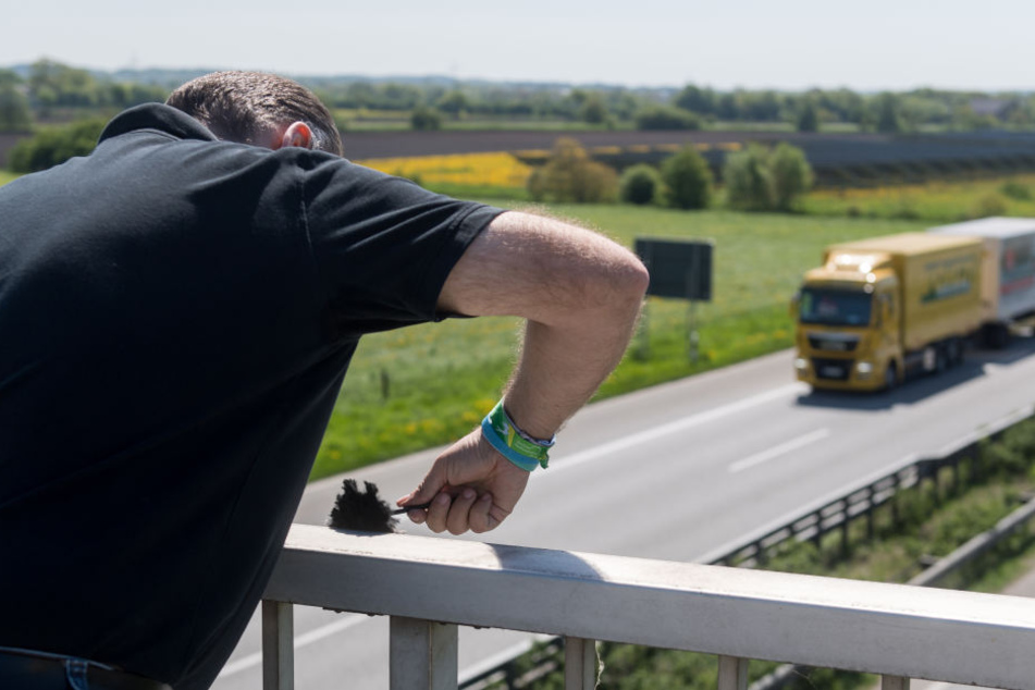 Ein Ermittler der Polizei auf einer Autobahnbrücke.