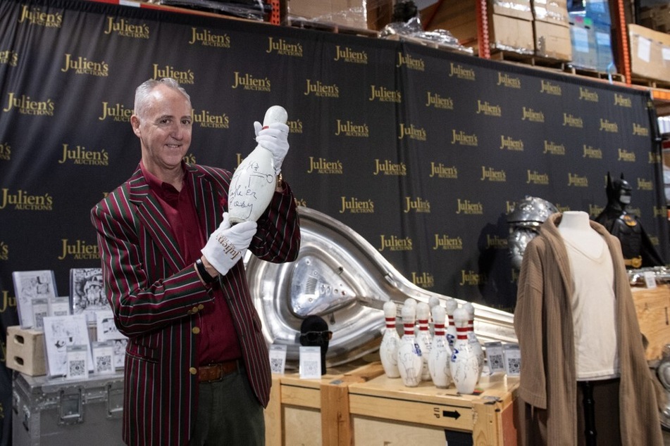 Executive Director and Co-Founder of Julien’s Auction Martin Nolan shows one of the The Big Lebowski signed film replica bowling pins during a press preview ahead of the public exhibition and auction.