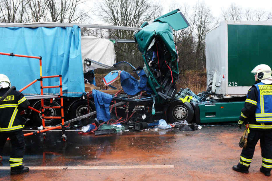 Rettungskräfte stehen vor dem verunglückten Lastwagen.
