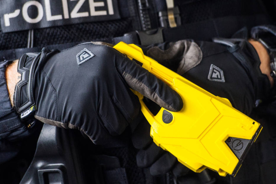 Eine Elektroschock-Waffe in der Hand eines Polizisten.
