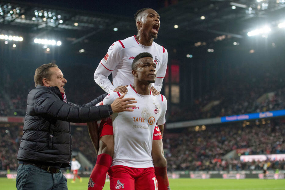 Kölns Sportdirektor Horst Heldt (l), Kingley Ehizibue (oben) und Torschütze Jhon Cordoba jubeln nach dem Treffer zur 1:0 Führung.