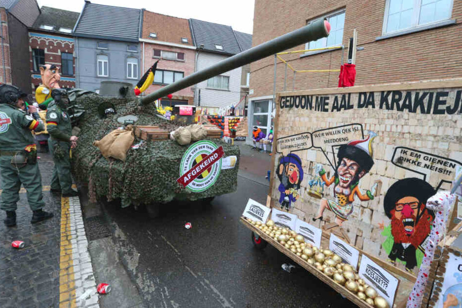 Kostümierte Männer nehmen mit einem Festzugswagen in Form eines Panzers am so genannten "Zondagstoet" (Sonntagsumzug) am Karneval in Aalst teil.