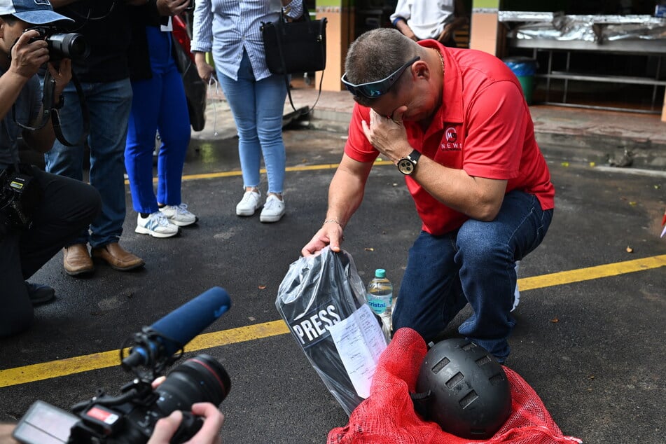 Salvadoran journalist Mario Guevara cries as he shows his journalist vest and helmet with which he was captured and deported from the US after spending three months in federal custody, in Olocuilta, El Salvador, on October 3, 2025.