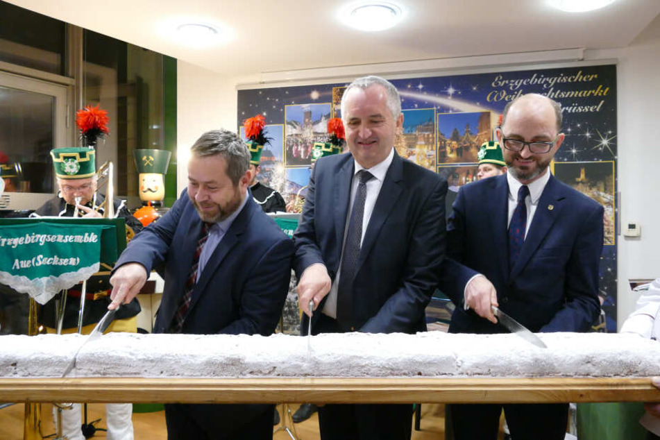 Staatsminister Thomas Schmidt (58, Mitte) schneidet den Stollen beim Erzgebirgischen Weihnachtsmarkt in Brüssel an.