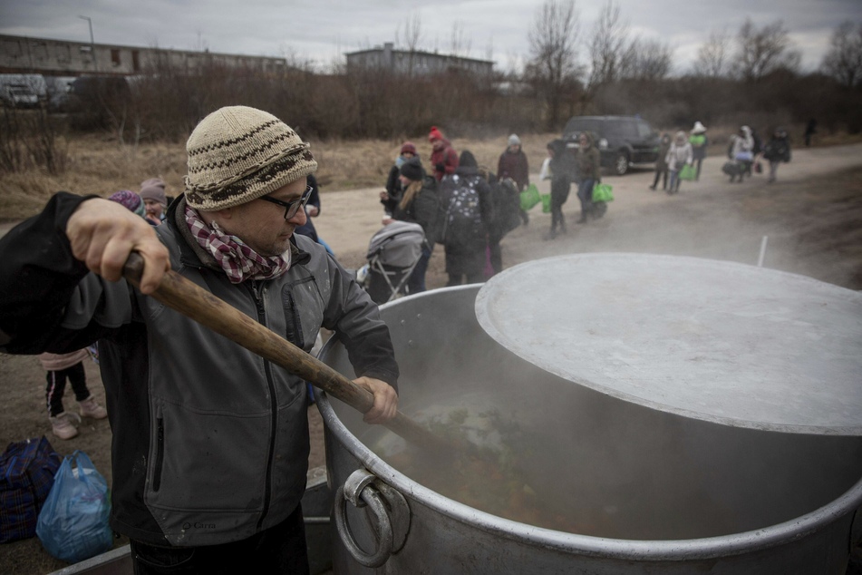 Der Freiwillige Lukas Saranga aus Tschechien kocht eine Suppe in einem riesigen Topf für Geflüchtete, die aus der Ukraine nach Polen geflohen sind.