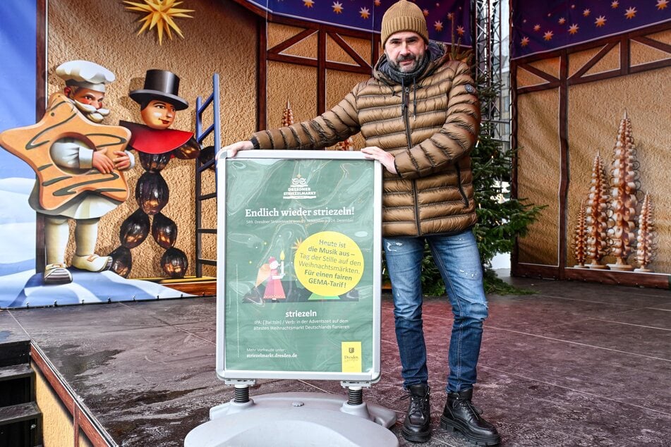 Kulturveranstalter Alexander Siebecke (51) mit dem Protestplakat auf der leeren Marktbühne.
