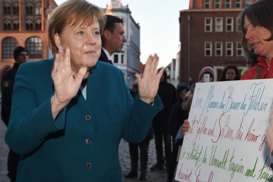 Bundeskanzlerin Angela Merkel (64, CDU) spricht vor dem Jahresempfang des Wirtschaftsrates der CDU auf dem Alten Markt mit Demonstranten einer Schülerdemo.
