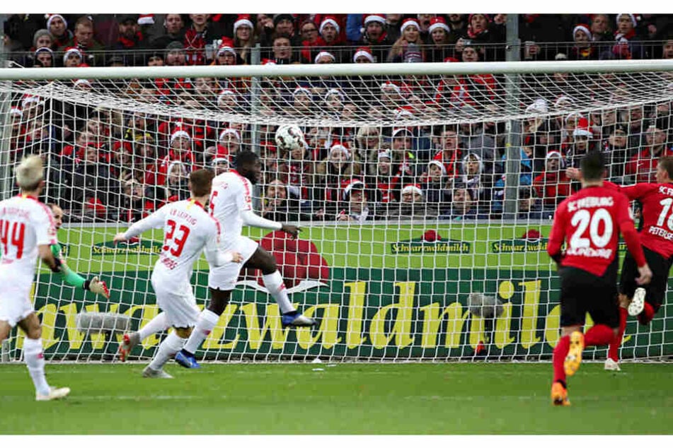 Das 1:0: Nach einem Abpraller von Péter Gulácsi (l., grünes Trikot) stochert Freiburgs Nils Petersen (r.) den Ball aufs Tor. Sowohl der Keeper als auch Ibrahima Konaté (3.v.r.) springen darunter durch.