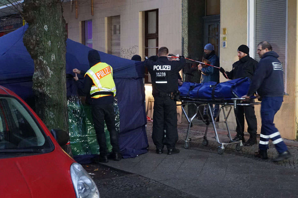 Die Leiche der toten Frau wird von den Ermittlern abtransportiert.