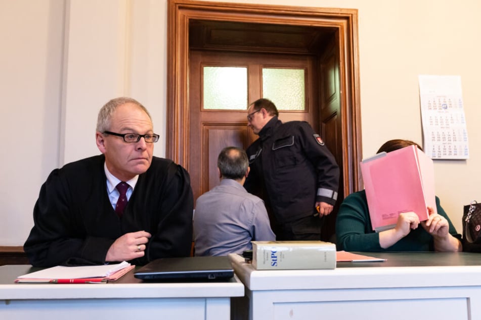 Die 48-jährige Angeklagte verdeckt im Amtsgericht neben Anwalt Uwe Bartscher ihr Gesicht.
