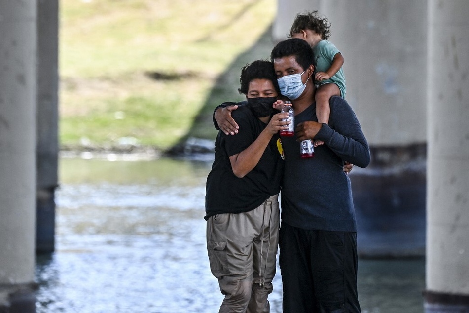 A migrant couple hug as they are apprehended by US Border Patrol and National Guard troops in Eagle Pass, Texas, near the border with Mexico.