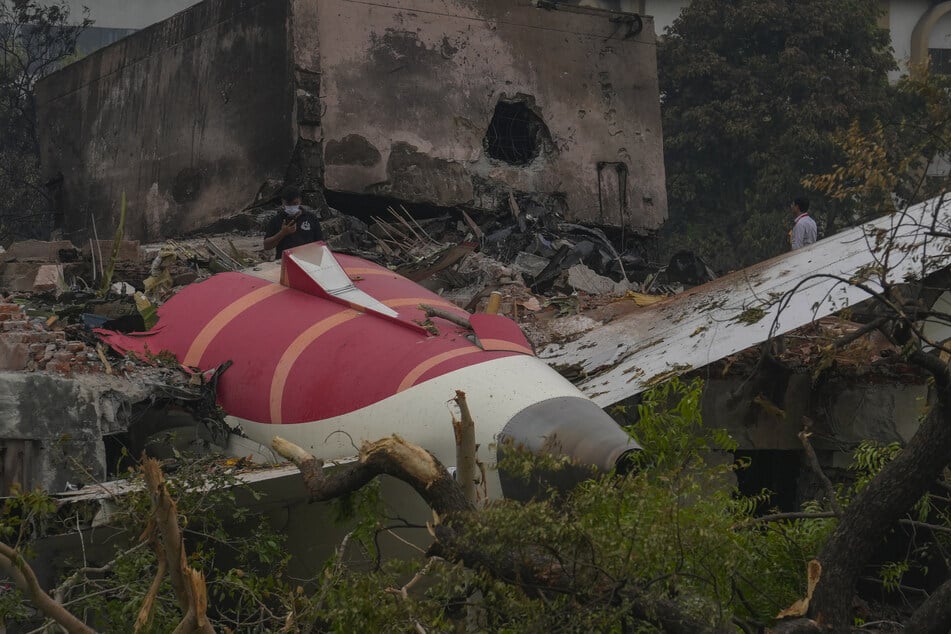 Teile des Flugzeugwracks liegen auf dem Boden verstreut.