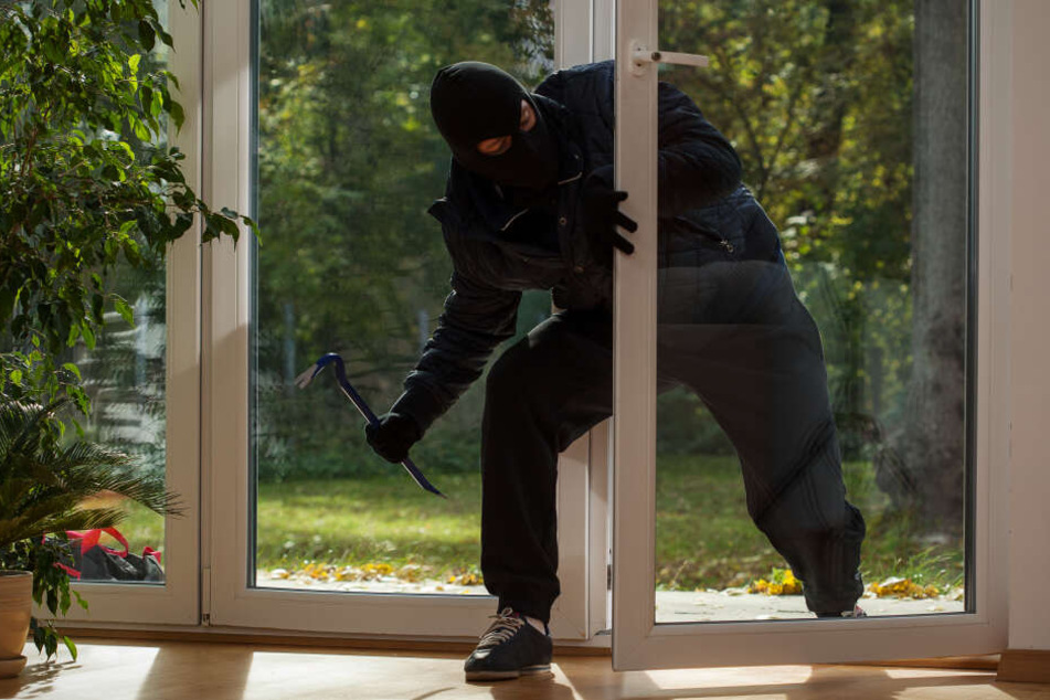 Per Werkzeug kommt dieser Einbrecher durch ein Fenster. (Symbolbild)