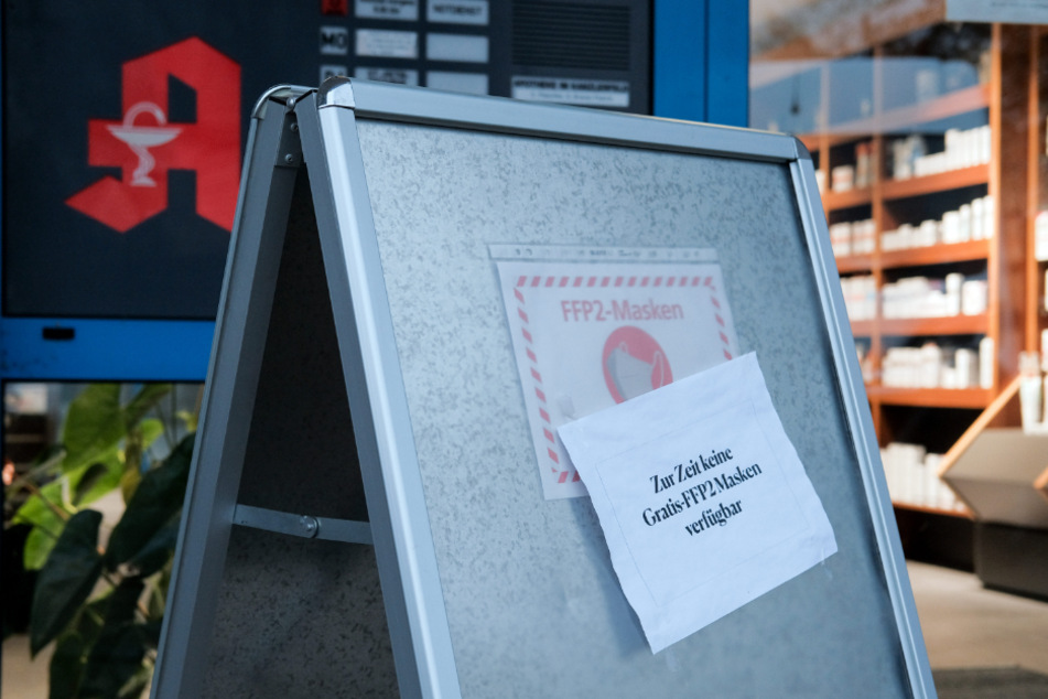 Ein Zettel mit der Aufschrift "Zur Zeit keine Gratis-FFP2-Masken verfügbar" hängt an einem Aufsteller vor einer Apotheke.