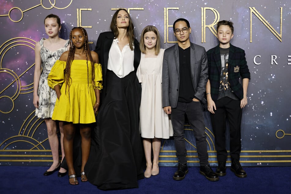 Angelina Jolie (3rd L) poses with her children, (L-R) Shiloh Jolie-Pitt, Zahara Jolie-Pitt, Vivienne Jolie-Pitt, Maddox Jolie-Pitt, and Knox Jolie-Pitt on the red carpet of the UK Gala Screening of the film Eternals in London on October 27, 2021.