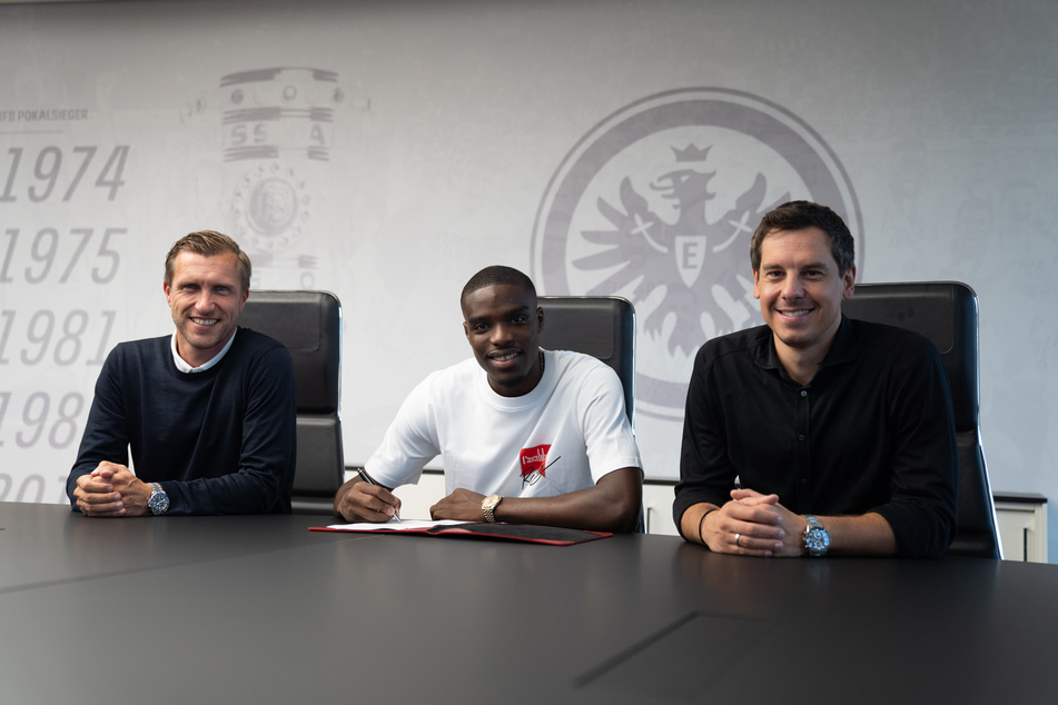 Eintracht-Neuzugang Niels Nkounkou (22, M.) bei seiner Vertragsunterzeichnung zusammen mit Sportvorstand Markus Krösche (42, l.) und Sportdirektor Timmo Hardung (33).