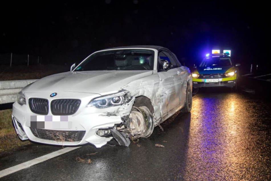 Der völlig zerbeulte 2er BMW steht an der Leitplanke.
