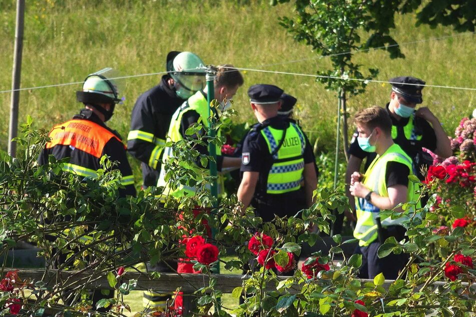 Die Rettungskräfte stehen um den Unfallort herum.
