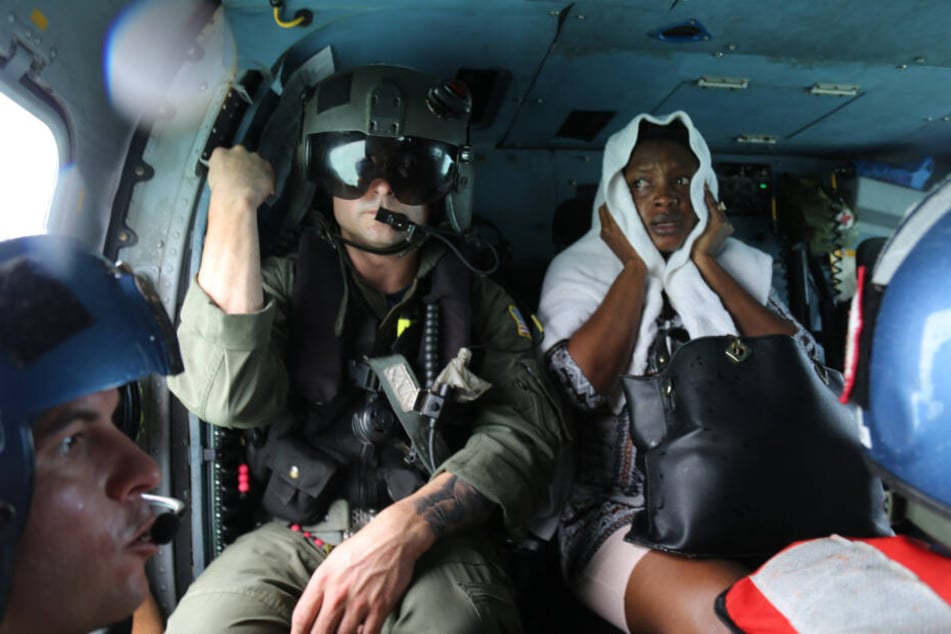 Ein Mitglied der US-Küstenwache sitzt neben einer verletzten Überlebenden, die nach dem Hurrikan Dorian von Marsh Harbour auf Great Abaco Island per Hubschrauber evakuiert wird.