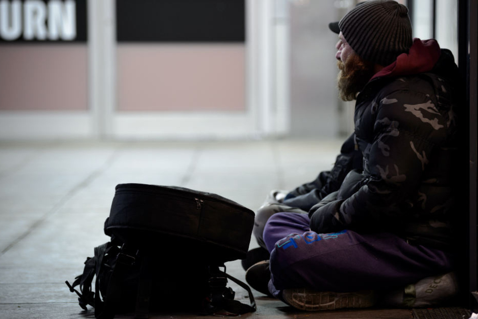 Zwei Obdachlose sitzen in Stuttgart in einer Unterführung.