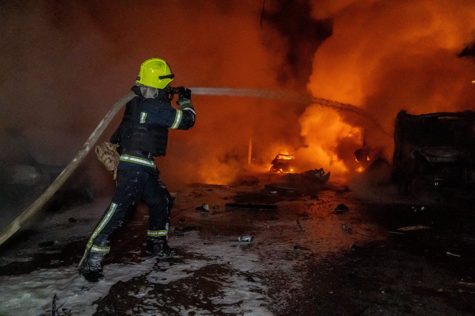 Rettungskräfte löschen ein Feuer in einem Wohnhaus, das durch einen russischen Angriff beschädigt wurde.