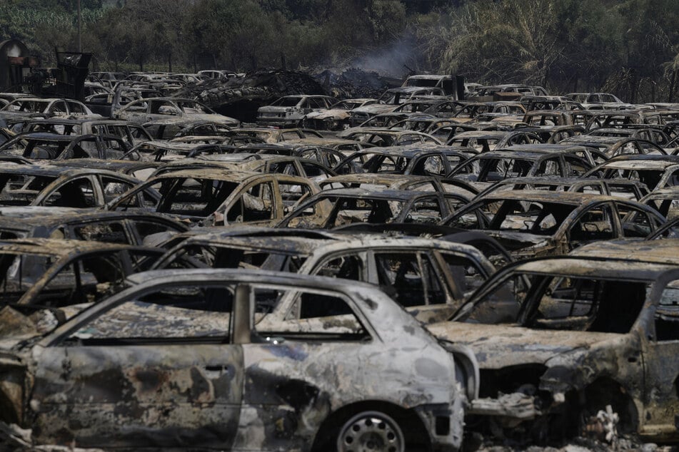 Ausgebrannte Autos sind auf einem Schrottplatz zu sehen, während eines Waldbrandes in der Nähe von Patras in Westgriechenland.