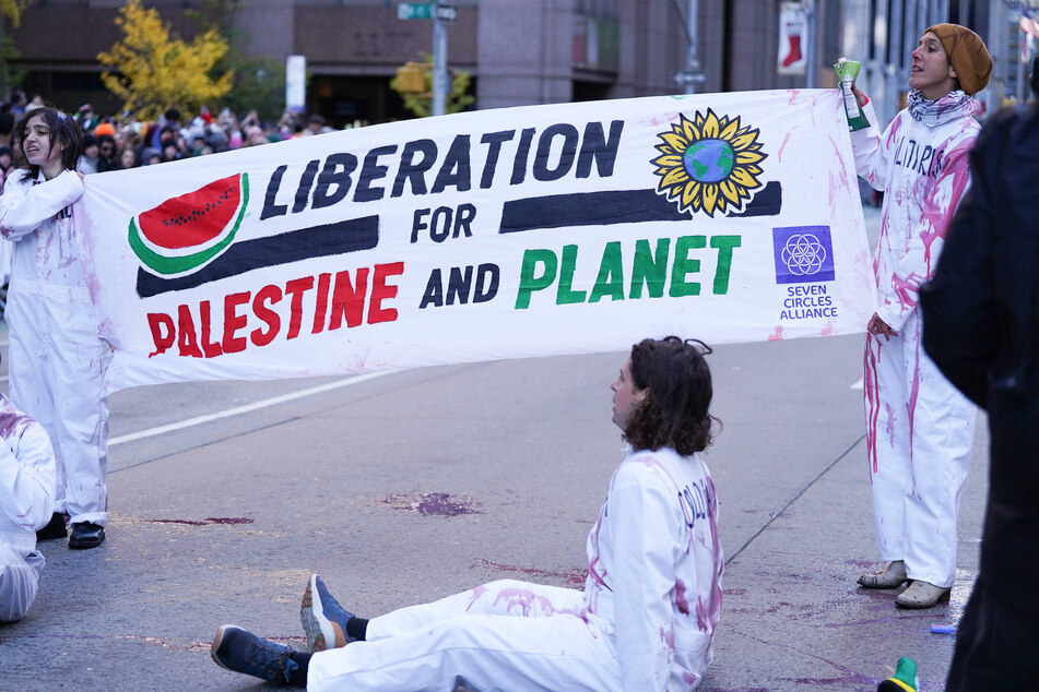 Activists stage a protest in the middle of the street during the Macy's Thanksgiving Parade in New York City, calling for Palestinian liberation and climate protections.