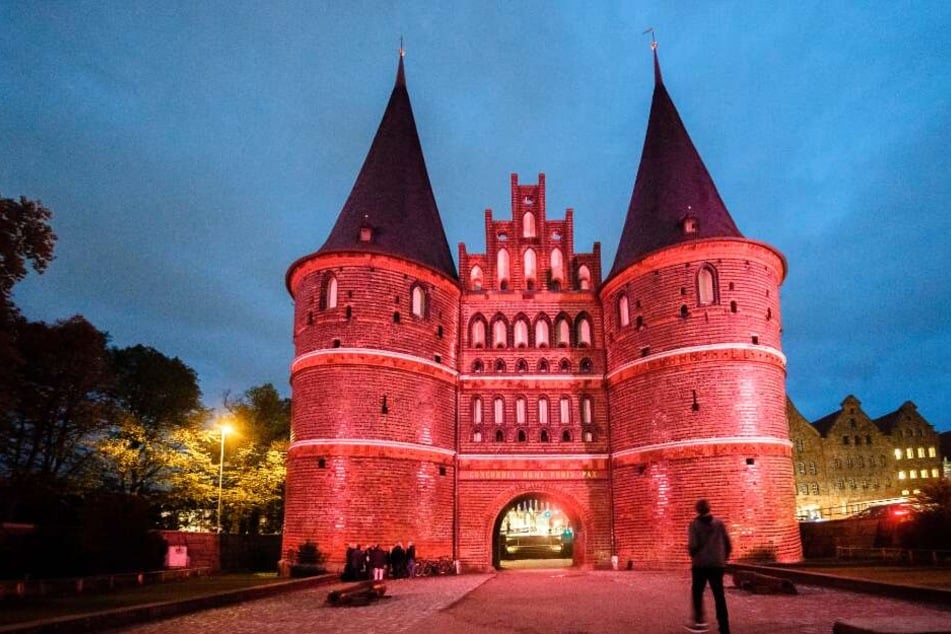 Das Lübecker Holstentor leuchtet in der Farbe Pink.