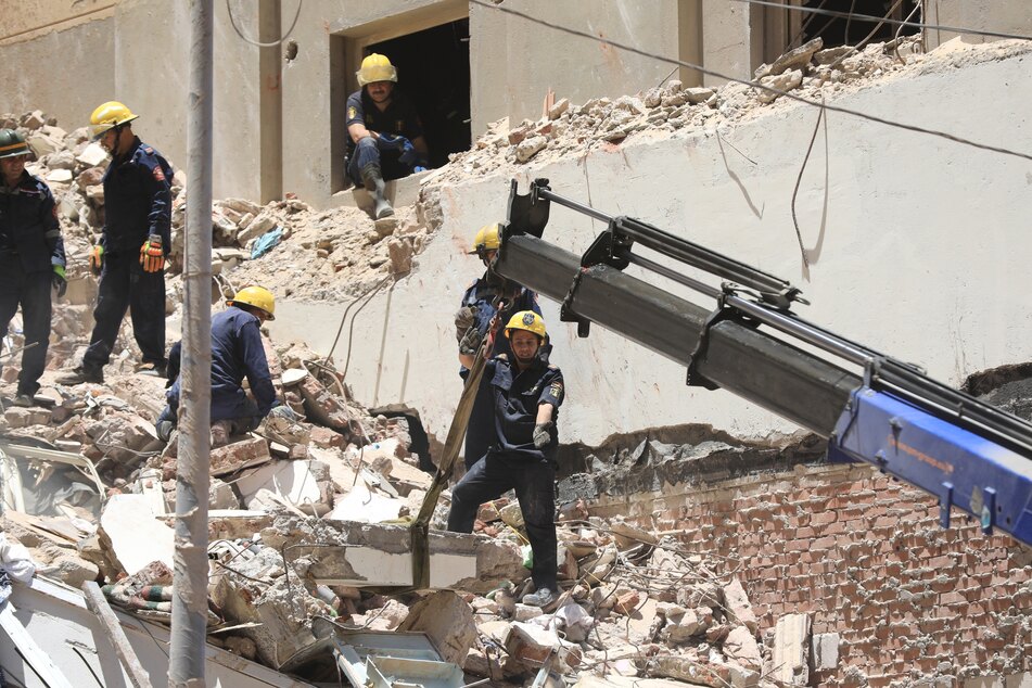 Mitglieder des ägyptischen Zivilschutzes arbeiten an Überresten des eingestürzten 13-stöckigen ohngebäudes im Stadtteil El-Montazah.
