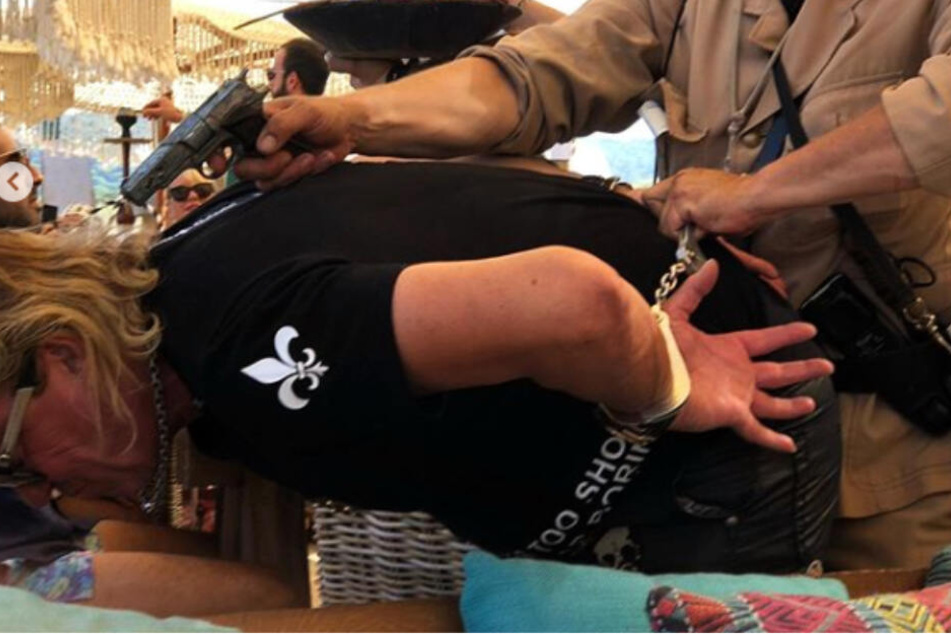 Ein Polizist hält Robert Geiss eine Waffe an den Kopf.