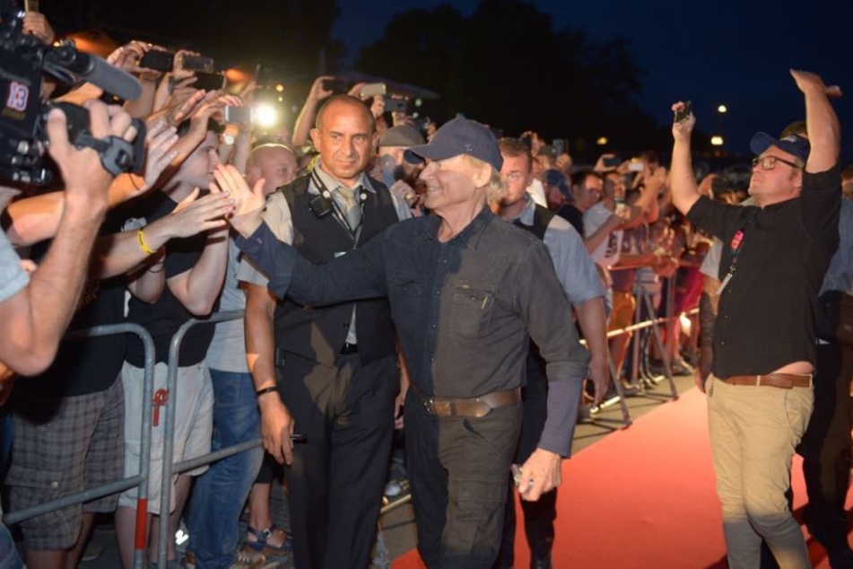 Der Schauspieler klatscht mit seinen Fans auf dem roten Teppich ab.