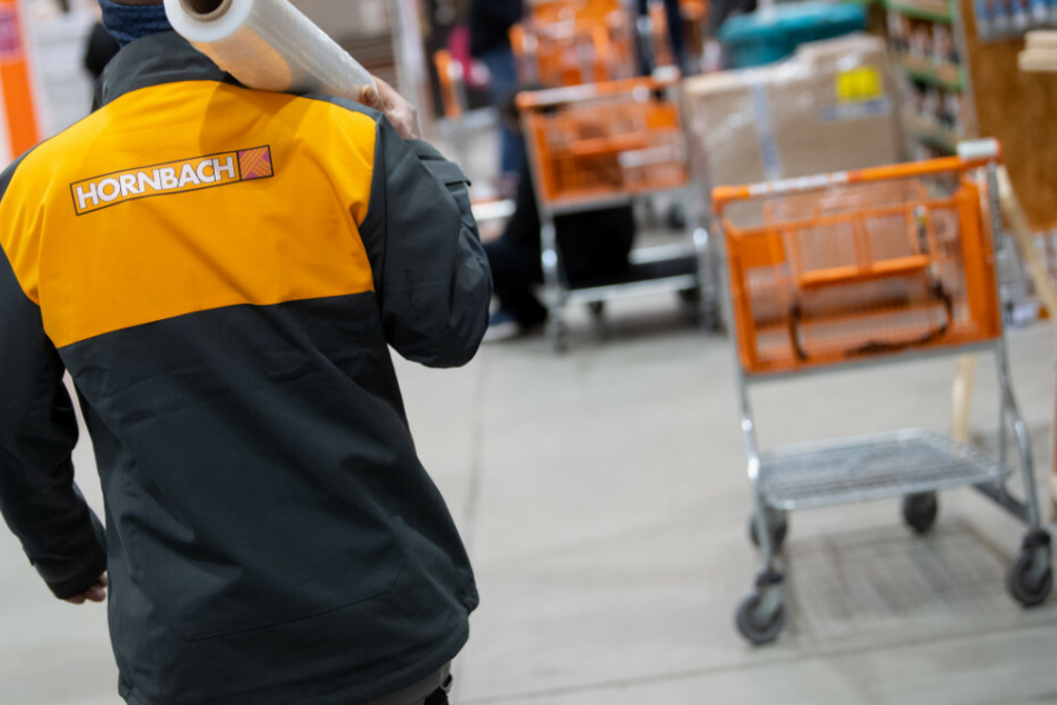 Große Familienunternehmen wie etwa Hornbach stehen im Fokus. Ein Mitarbeiter läuft durch einen Baumarkt im Freistaat Bayern. Die Mehrheit der Firmen will nach einer neuen Umfrage möglichst keine Arbeitsplätze abbauen.