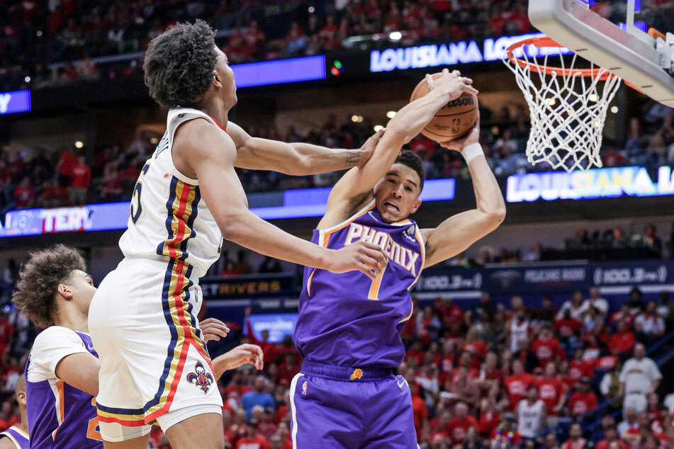 Devin Booker (r.) scored a game-high 33 points against the Pelicans to send the Sun into the second round.